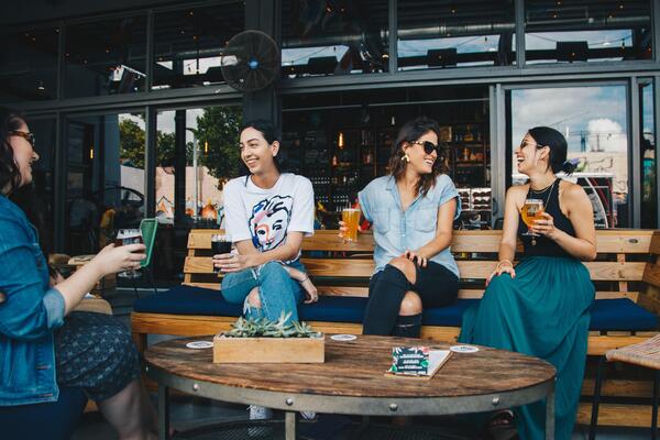 women sitting at an outdoor restaurant drinking