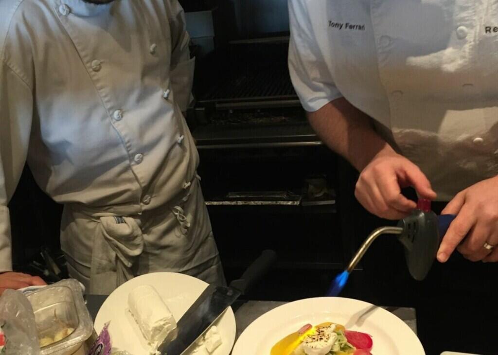 chef finishing off dish with a blow torch
